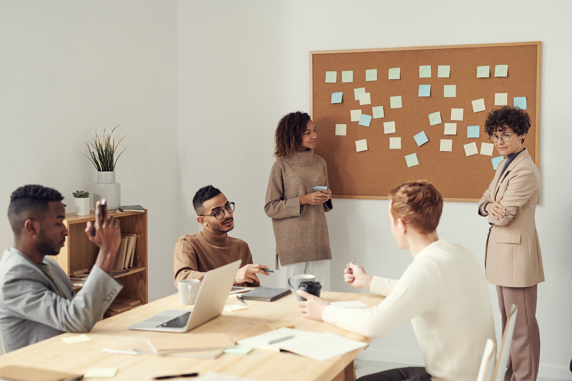 Een goed op elkaar ingespeeld team dat overlegt voor een bord met post-its